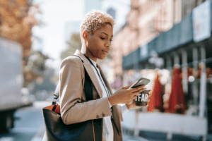 Woman reading solopreneur newsletter on her mobile phone