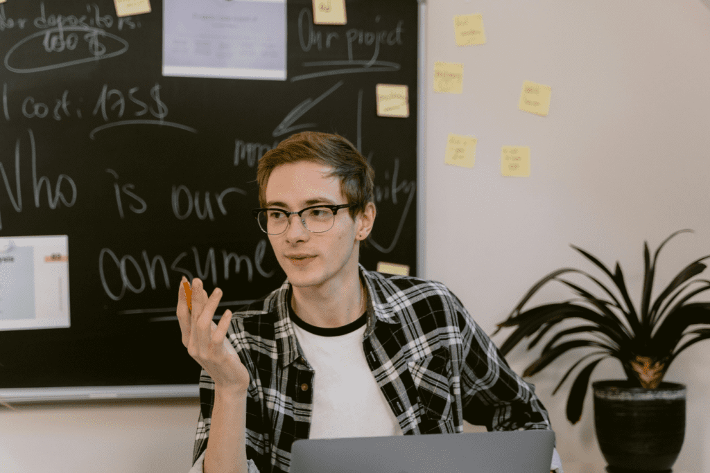 Young man sitting in his classroom with his laptop talking about his solopreneur business.