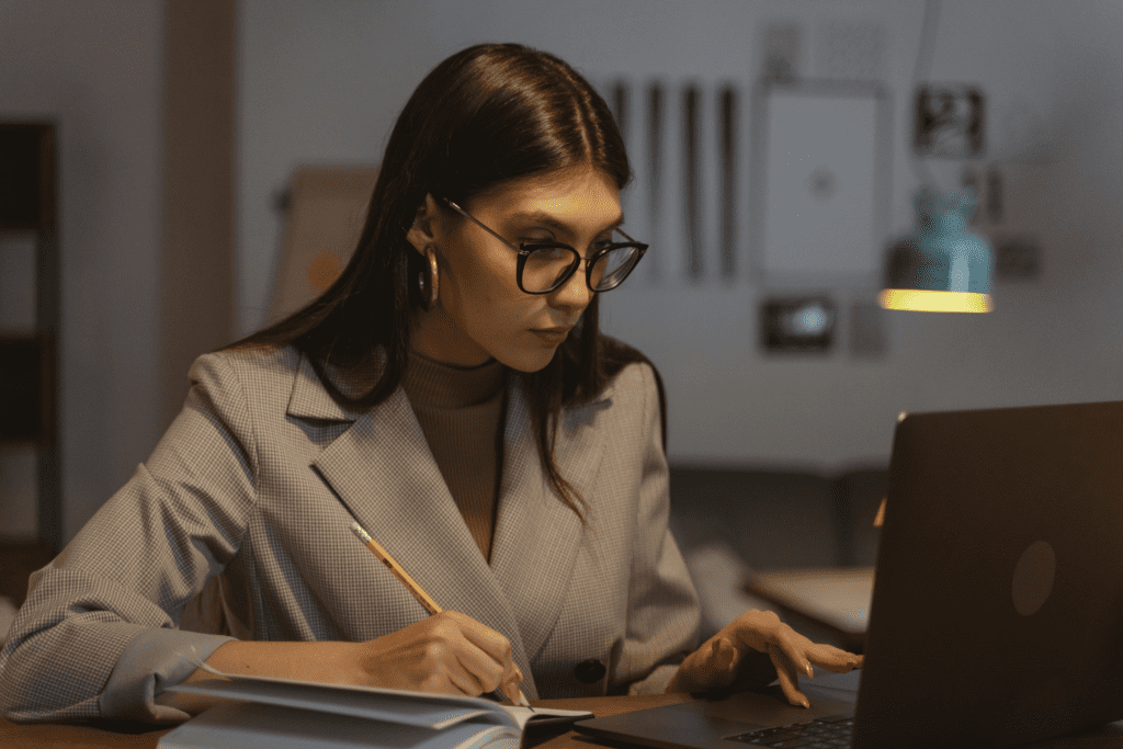 A young, solopreneur woman sitting in her home office and reading on her laptop