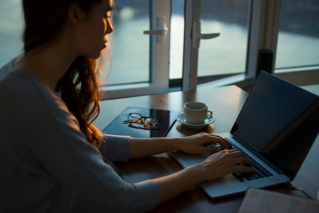 Young girl sitting and writing her solopreneur newsletter on her laptop.